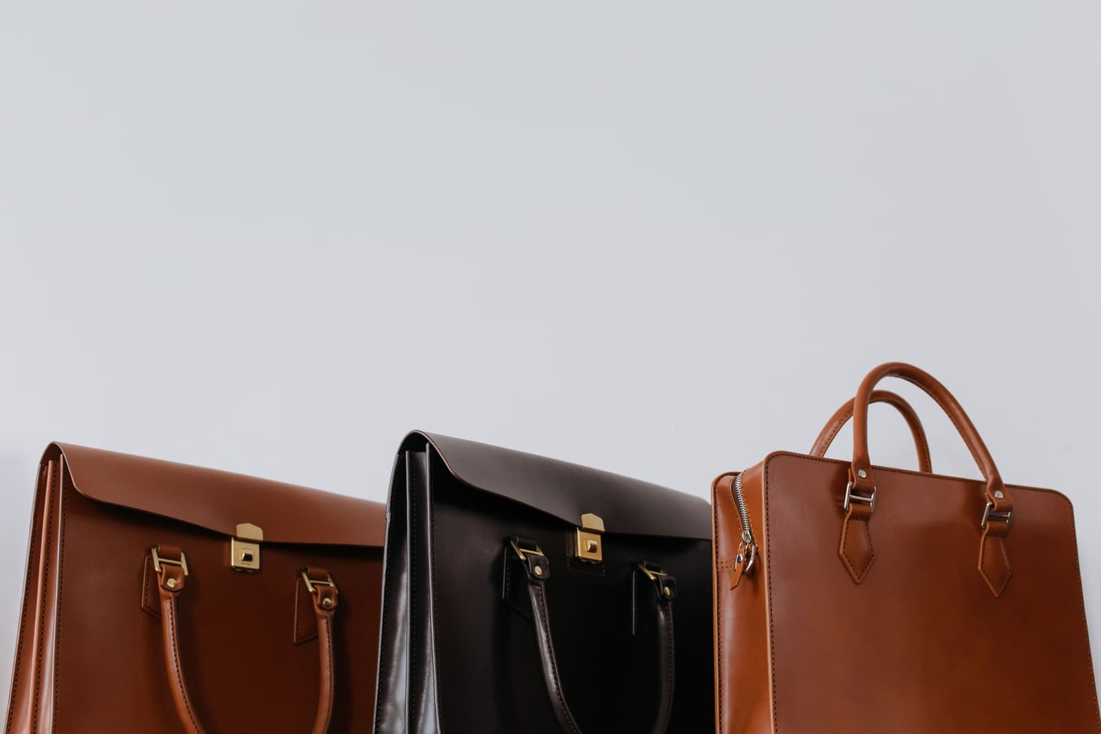 A curated row of structured leather bags